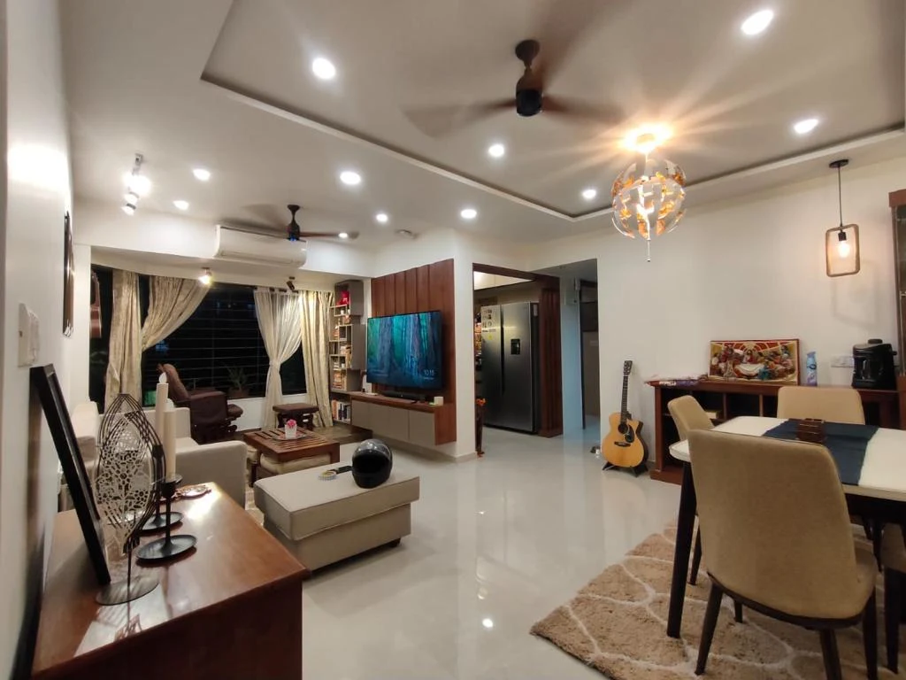 Open-plan living and dining with tray ceiling and wood-panelled TV wall